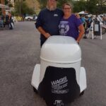 A couple holding a white pet trailer