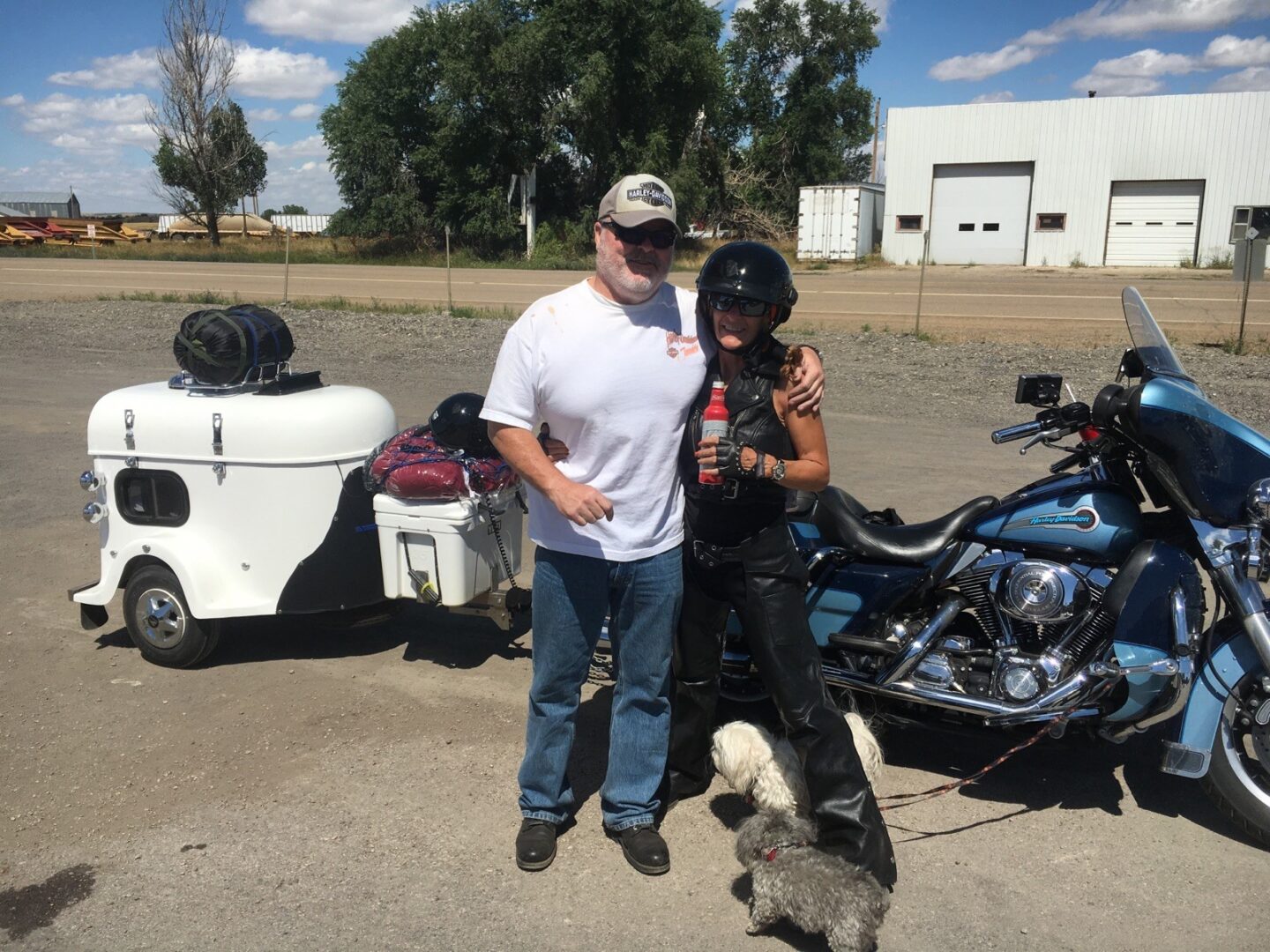 A couple with a dog wearing a cap and a helmet